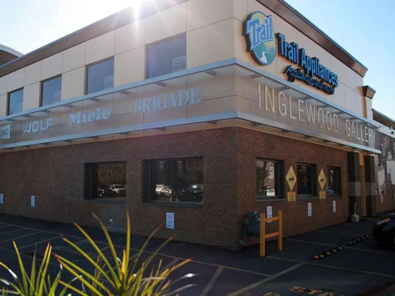 A corner building with an Inglewood sign and shops beneath a sunny sky
